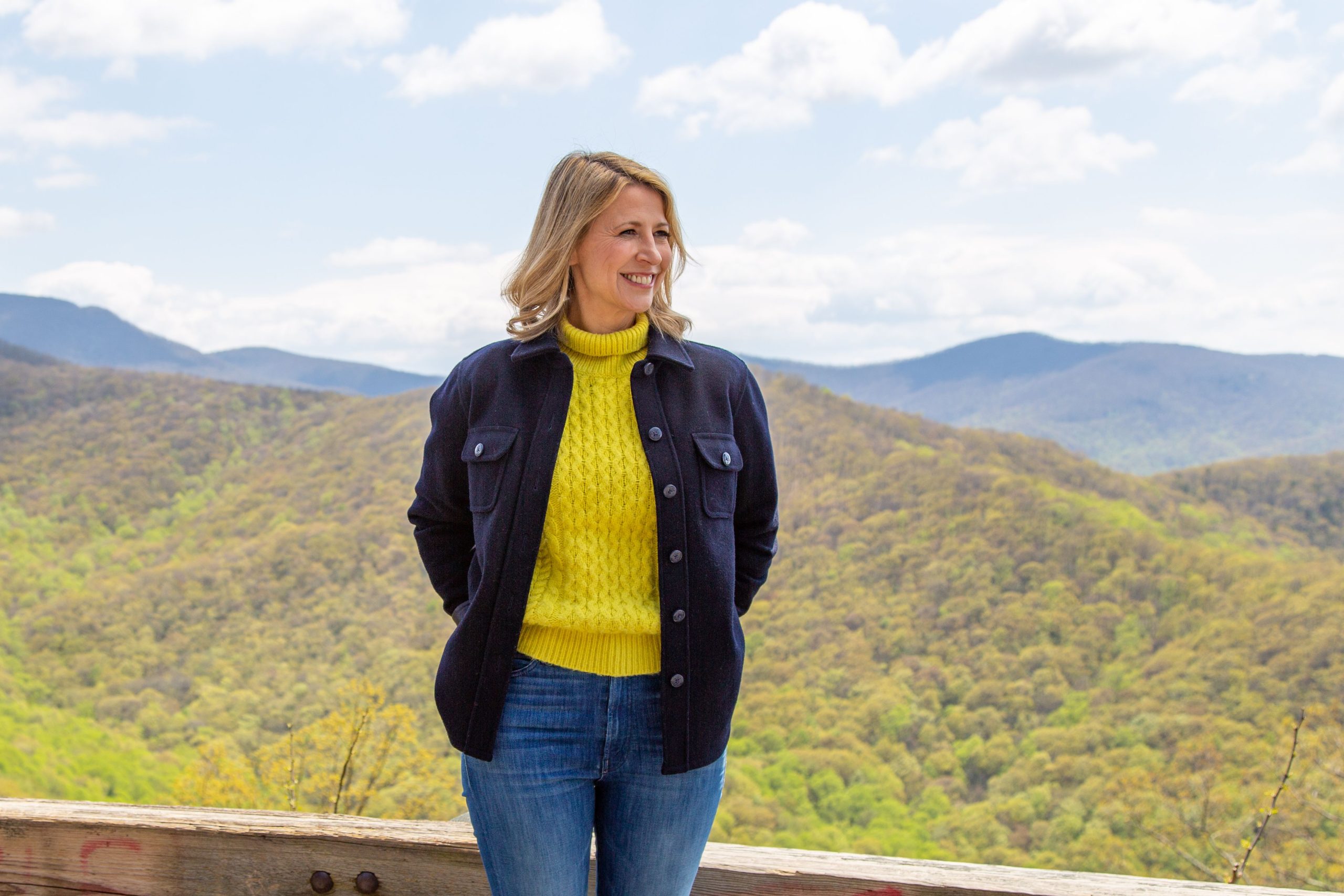 Samantha Brown standing in front of the Blue Ridge Mountains in Asheville North Carolina